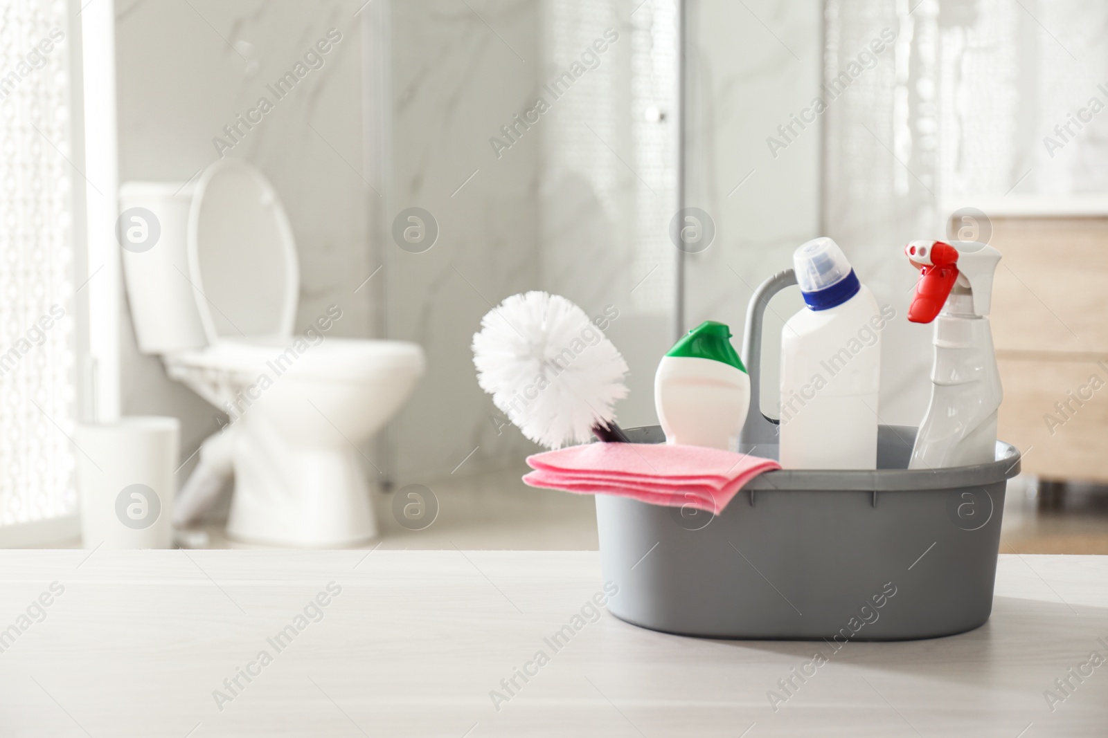 Photo of Cleaning supplies and toilet bowl in bathroom. Space for text