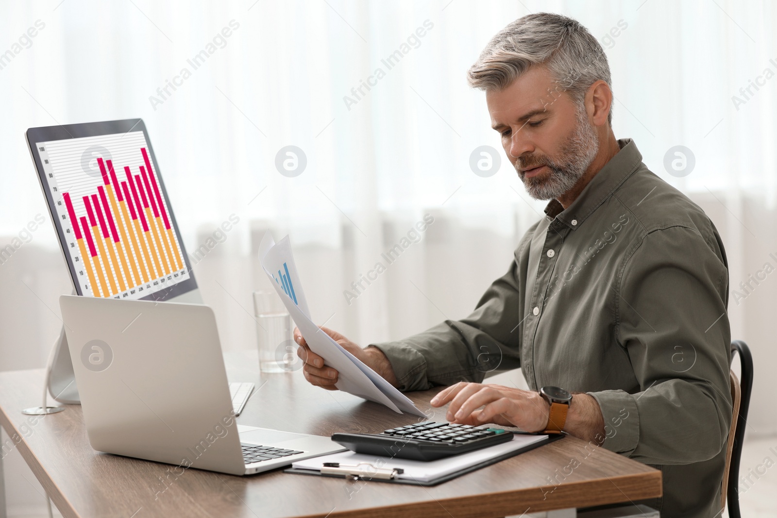 Photo of Professional accountant working at wooden desk in office