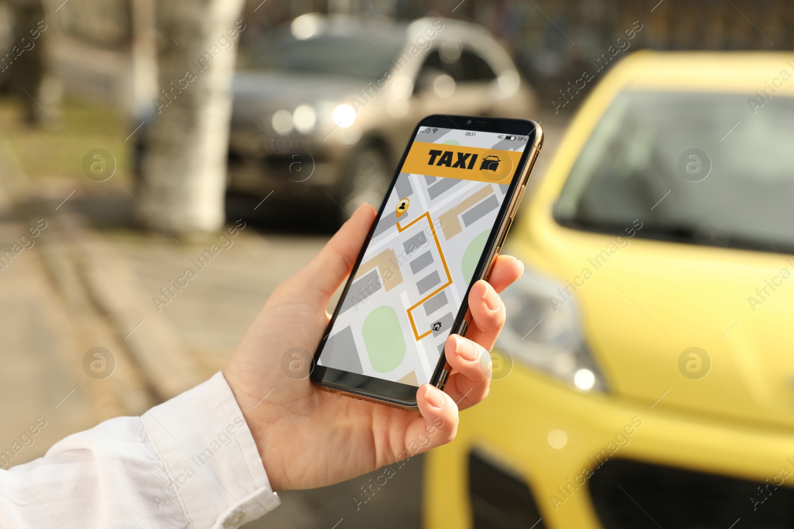 Photo of Woman ordering taxi with smartphone on city street, closeup