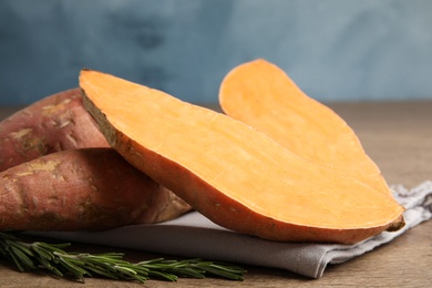 Photo of Composition with ripe sweet potatoes on wooden table, closeup