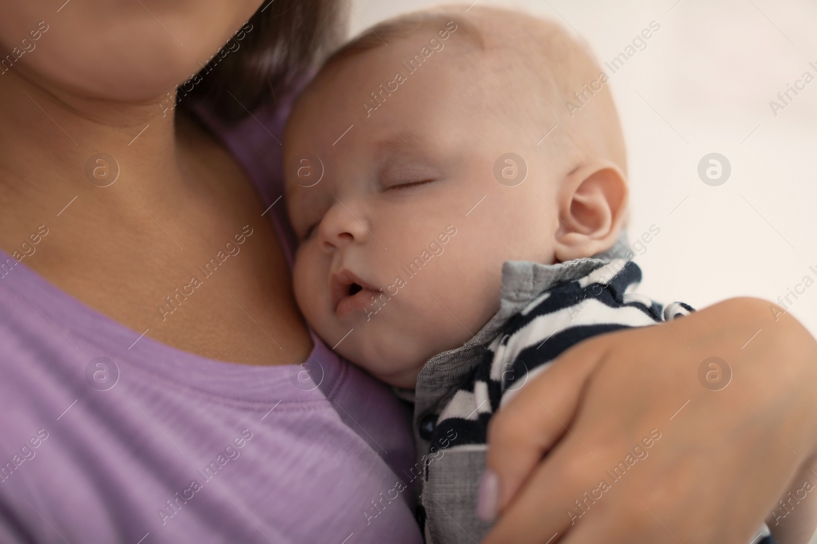 Photo of Mother with her sleeping baby at home, closeup view