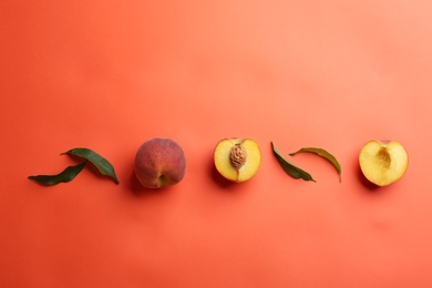 Photo of Flat lay composition with fresh peaches on coral background