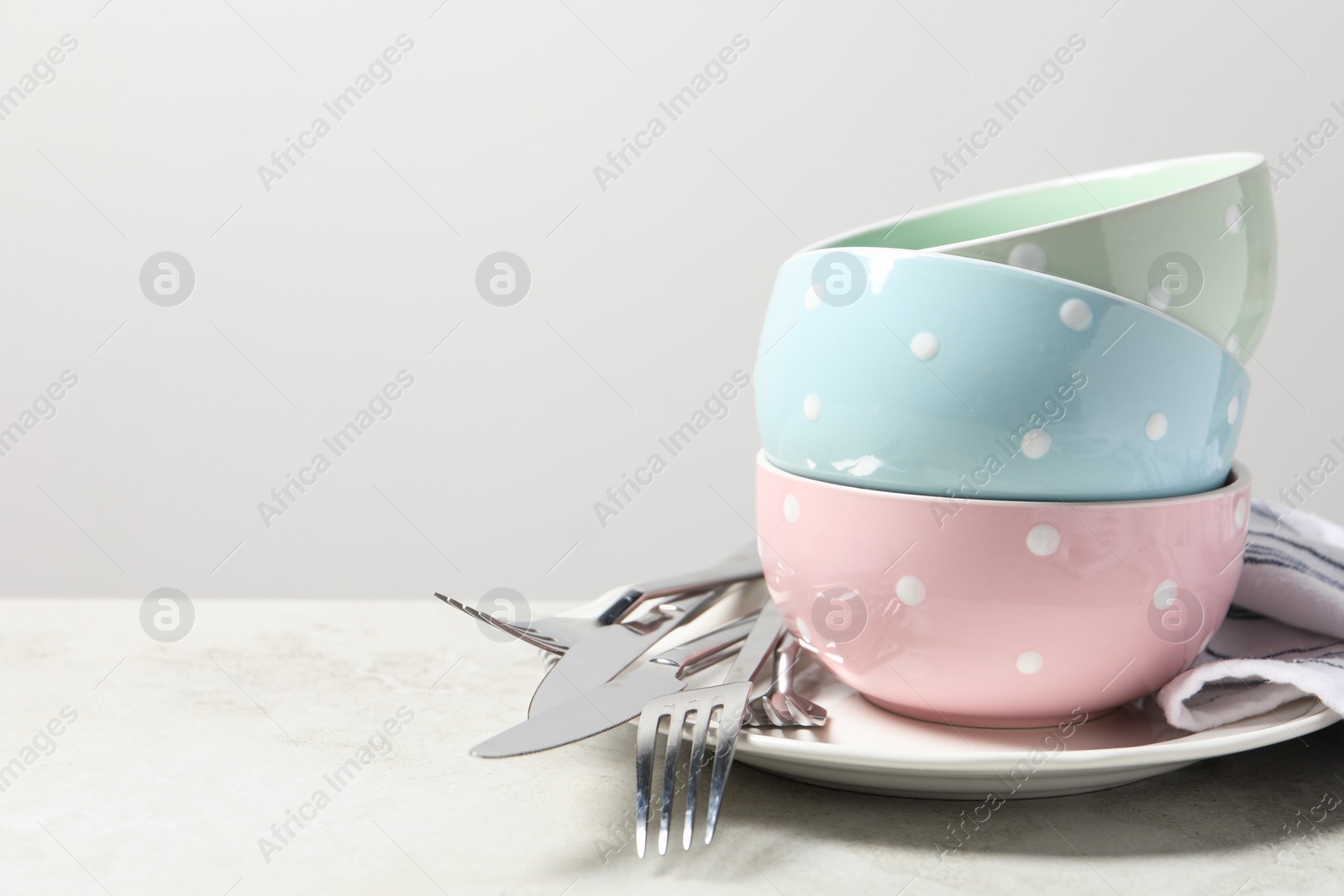 Photo of Beautiful ceramic dishware and cutlery on light grey table, space for text