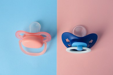 Photo of Baby pacifiers on color background, above view