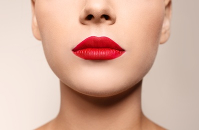 Photo of Beautiful young woman with red lips on color background, closeup