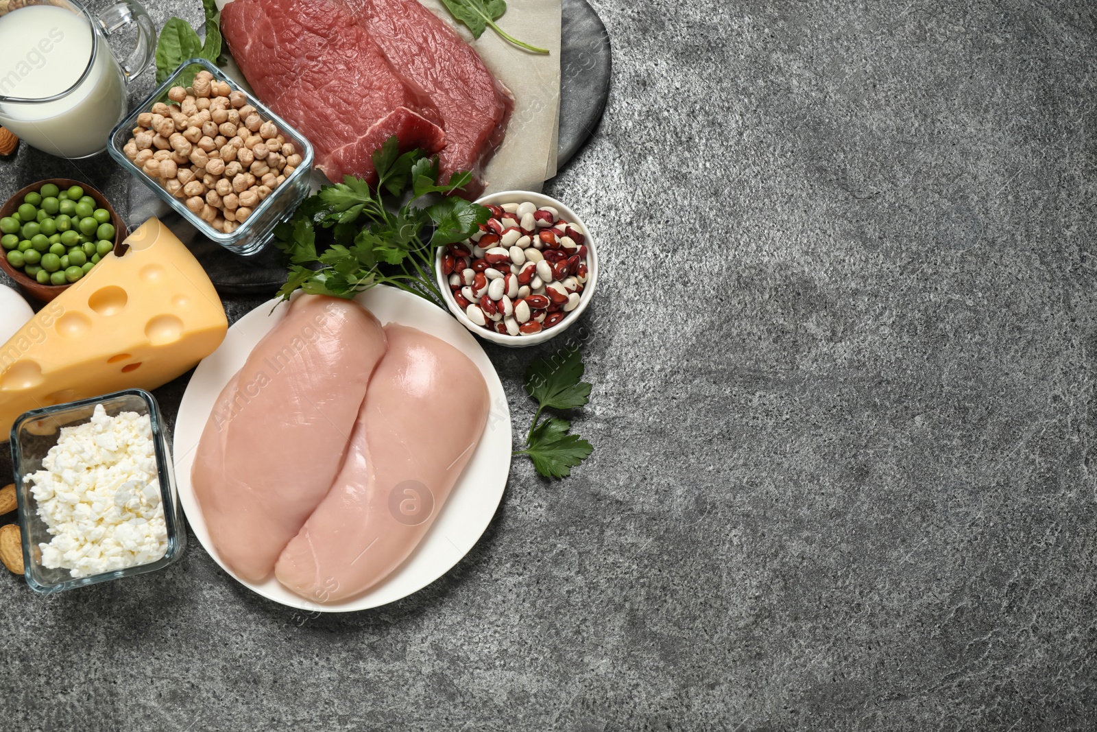 Photo of Products rich in protein on grey table, flat lay. Space for text