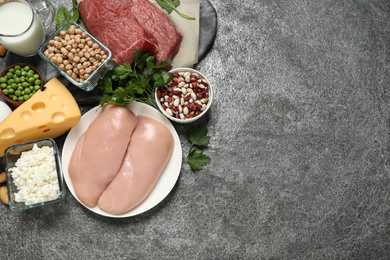 Photo of Products rich in protein on grey table, flat lay. Space for text