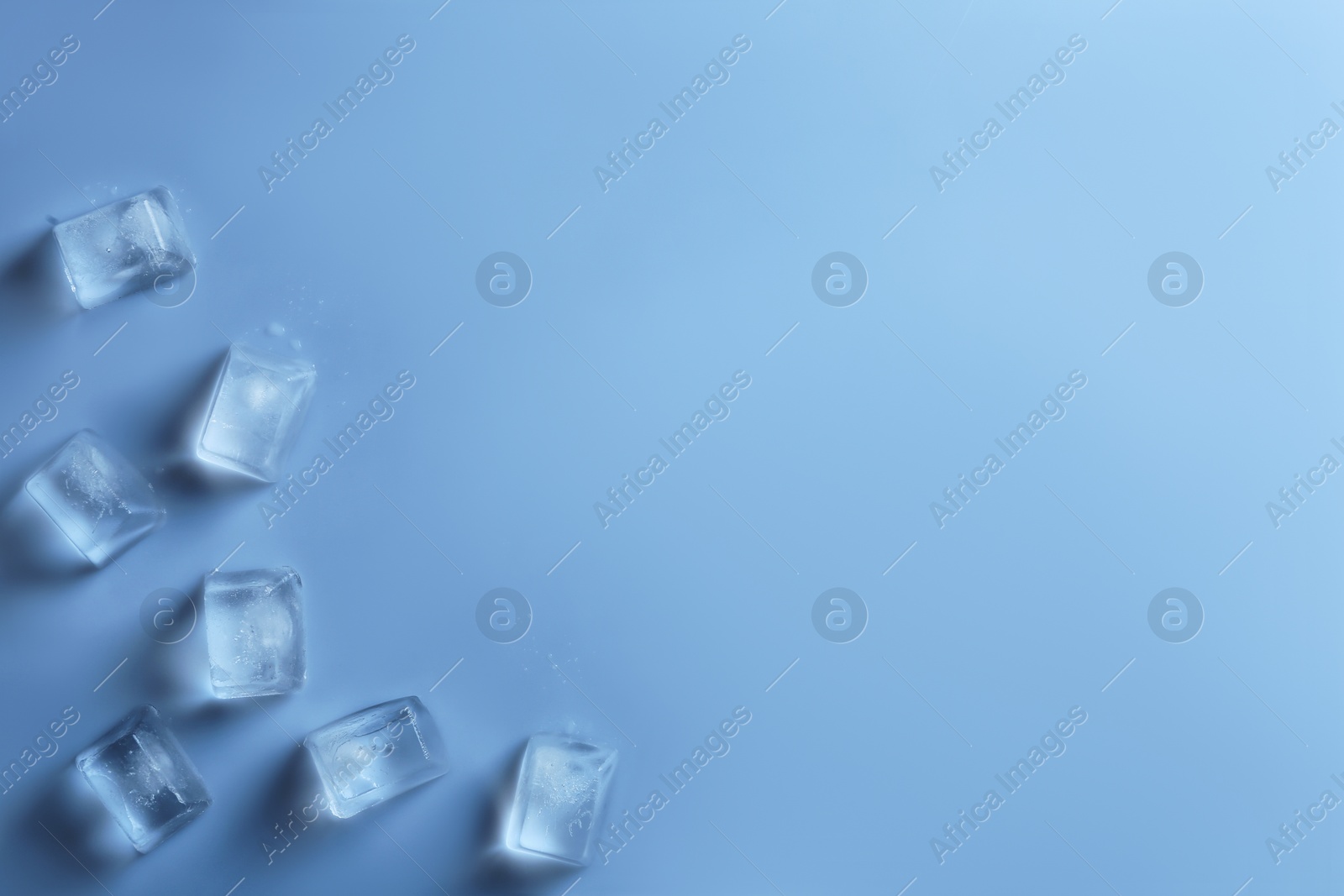 Photo of Ice cubes on color background, top view. Space for text