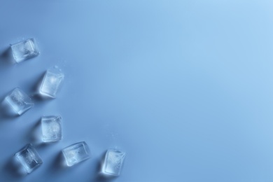 Ice cubes on color background, top view. Space for text