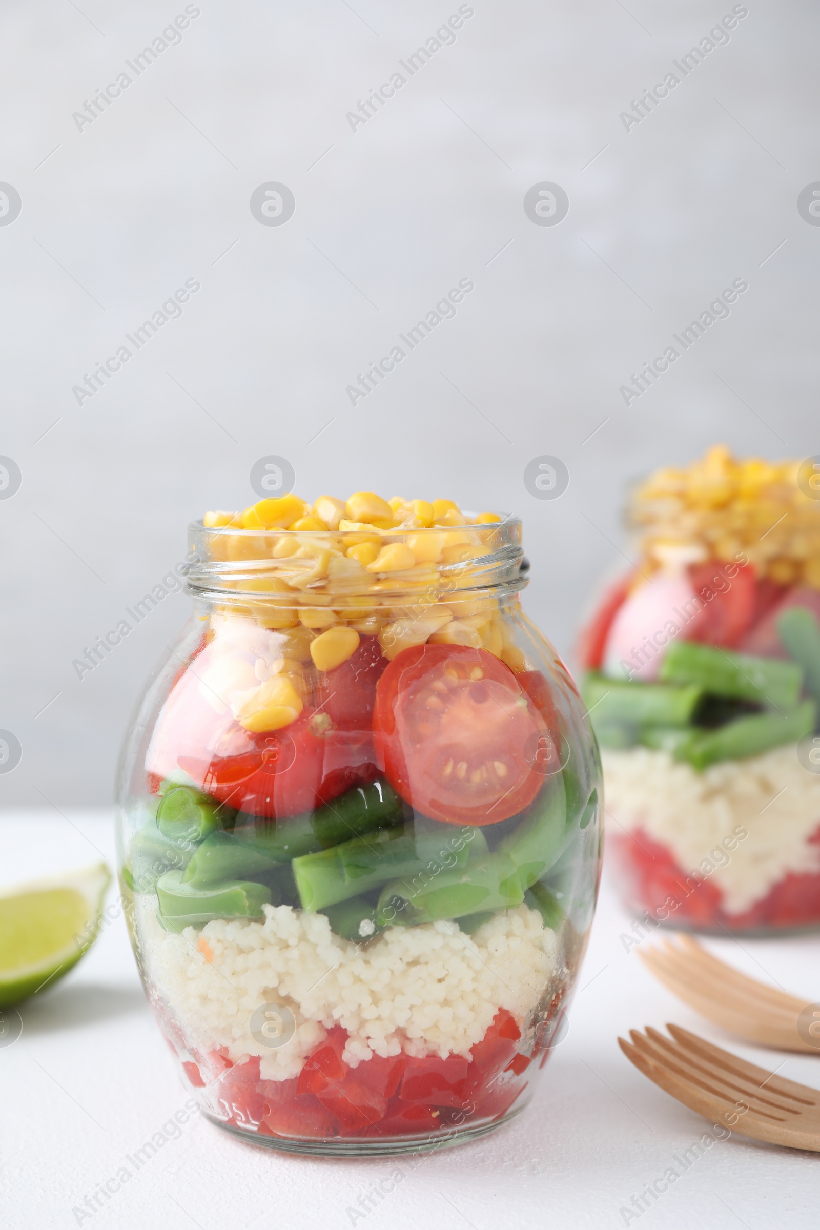 Photo of Healthy salad in glass jar on white table