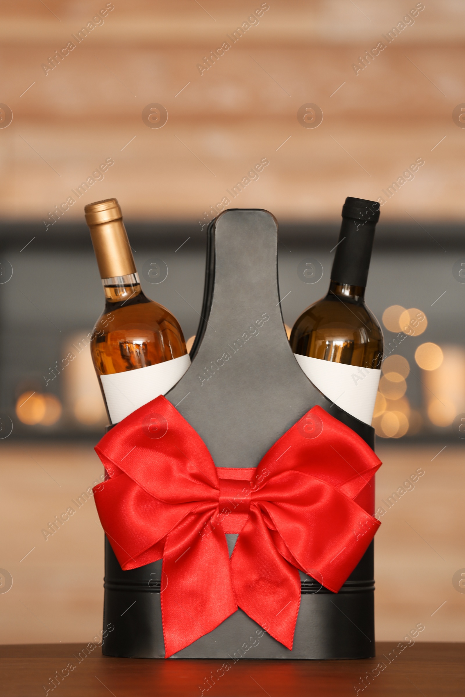 Photo of Festive package with bottles of wine on table in room