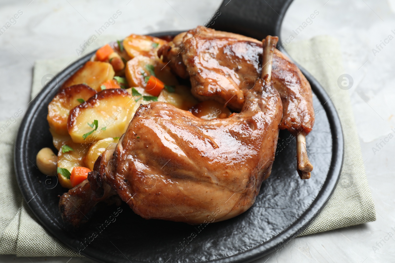 Photo of Tasty cooked rabbit meat with vegetables on table, closeup