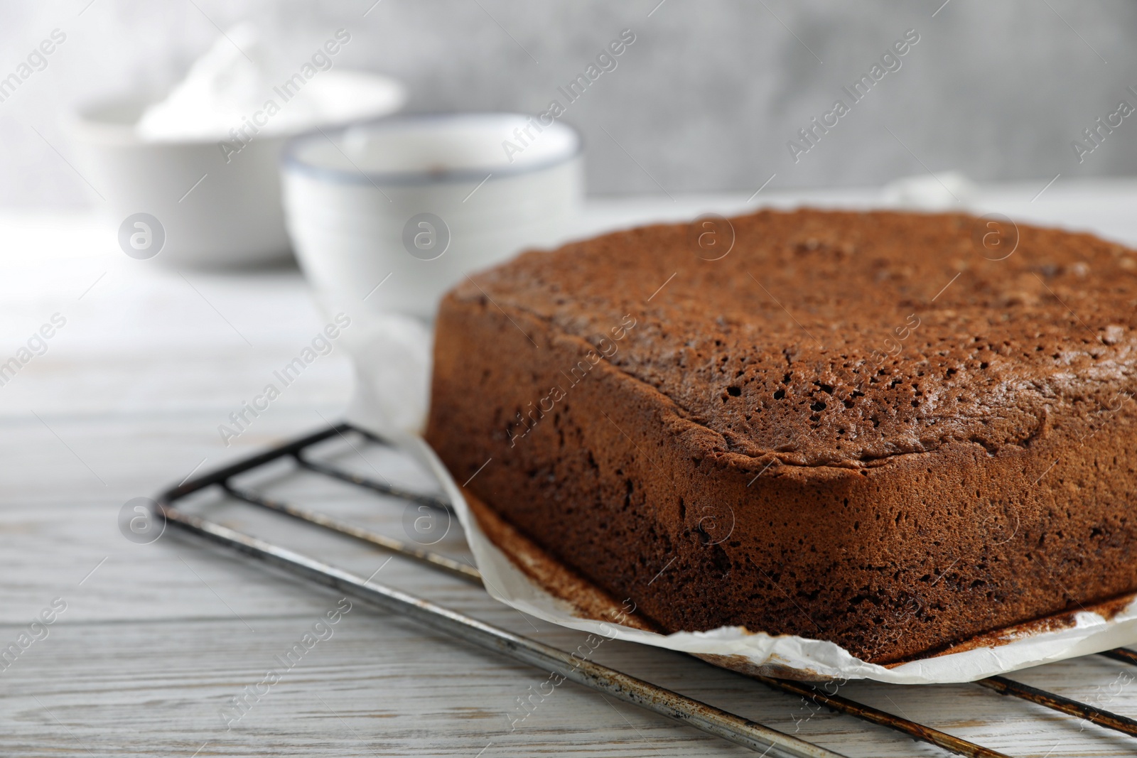 Photo of Homemade chocolate sponge cake on white wooden table, closeup. Space for text