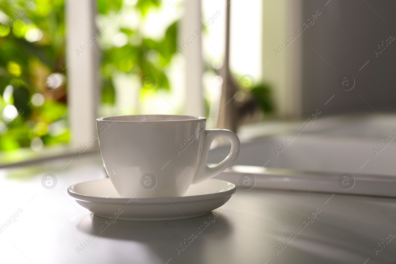 Photo of Cup of delicious coffee on kitchen countertop, space for text. Good morning