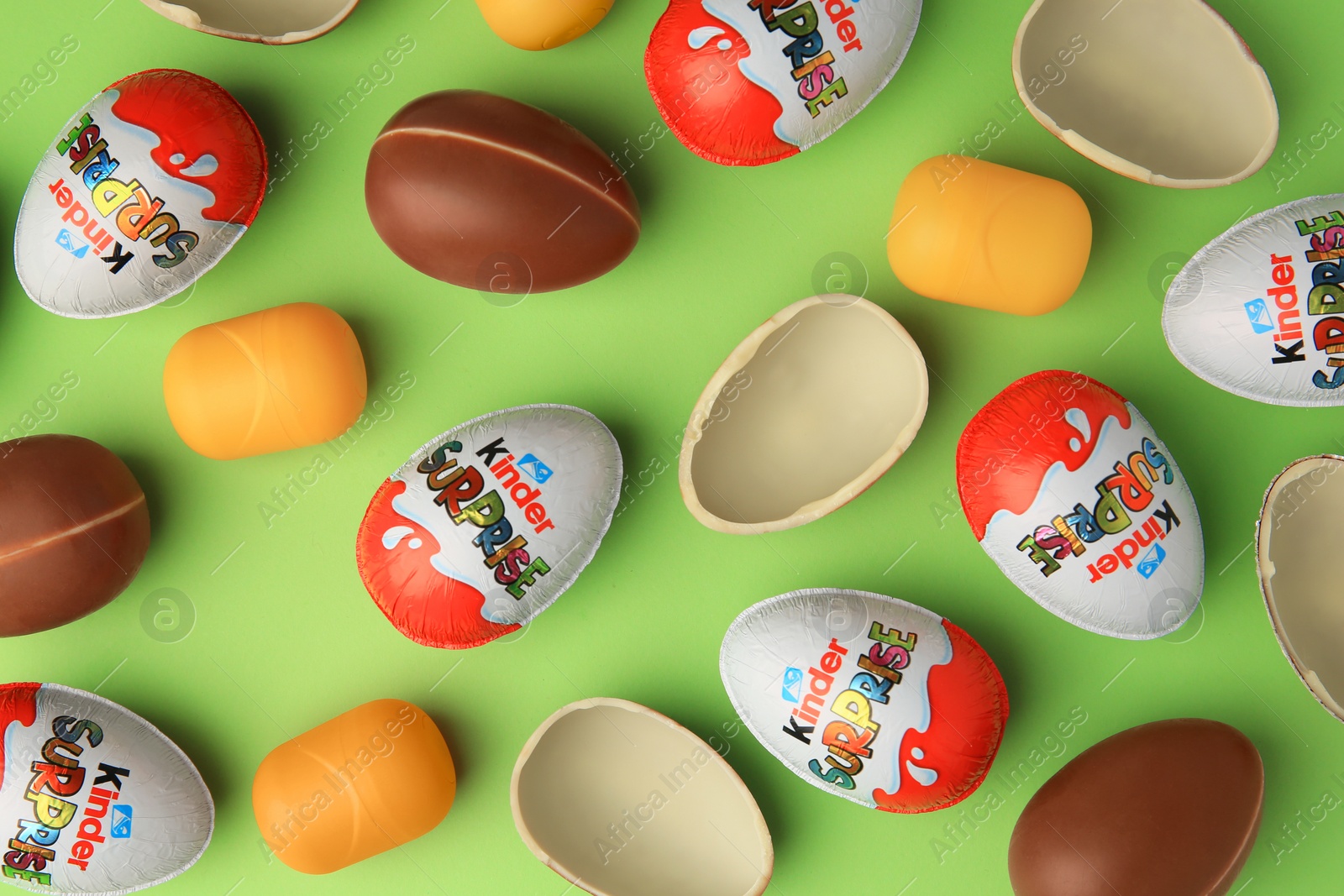 Photo of Sveti Vlas, Bulgaria - June 29, 2023: Kinder Surprise Eggs and plastic capsules on light green background, flat lay