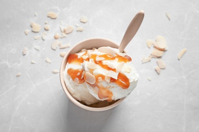 Bowl with caramel ice cream on light background