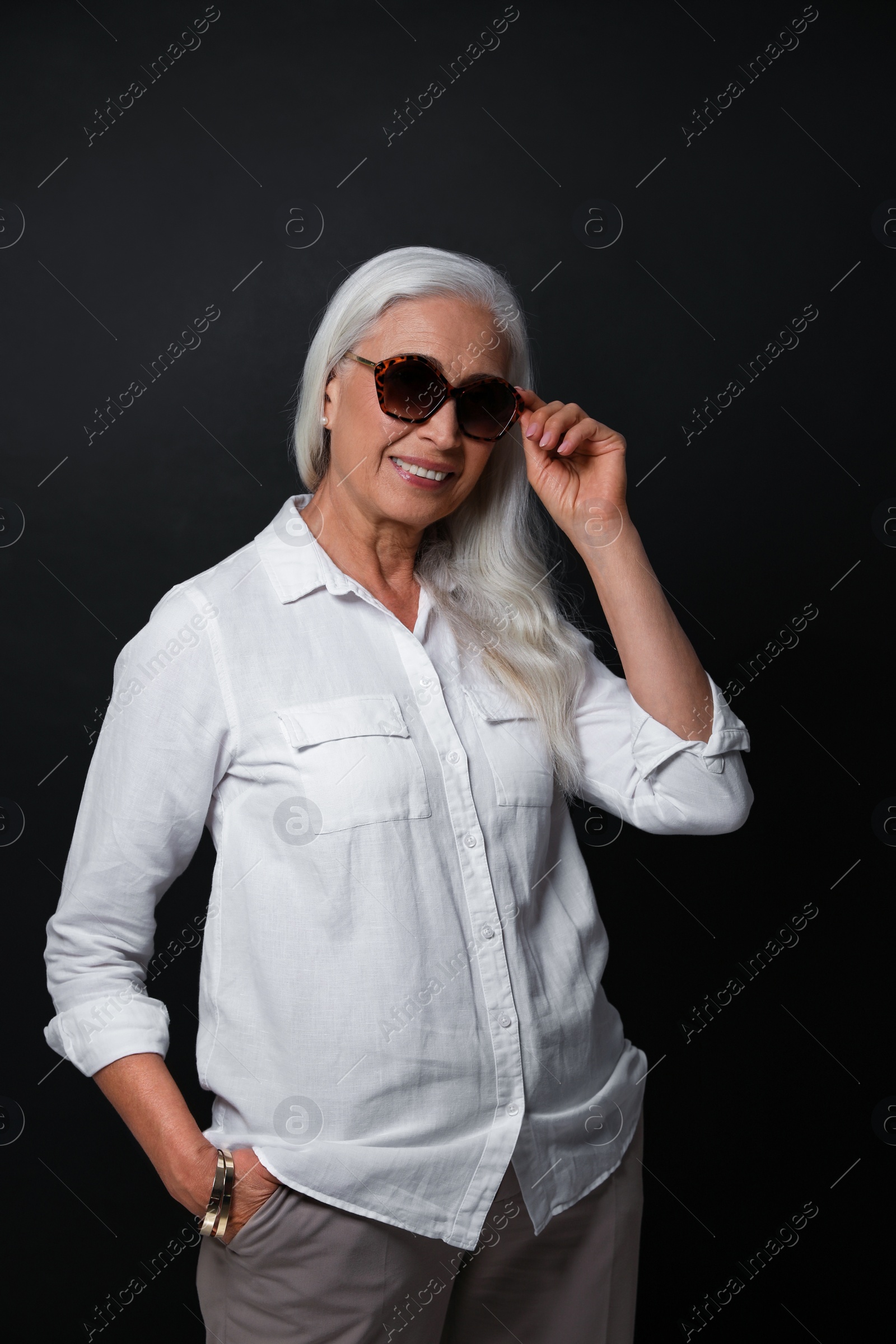 Photo of Portrait of beautiful mature woman on black background