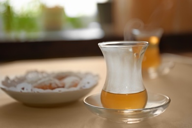 Photo of Glass cup of aromatic tea on table