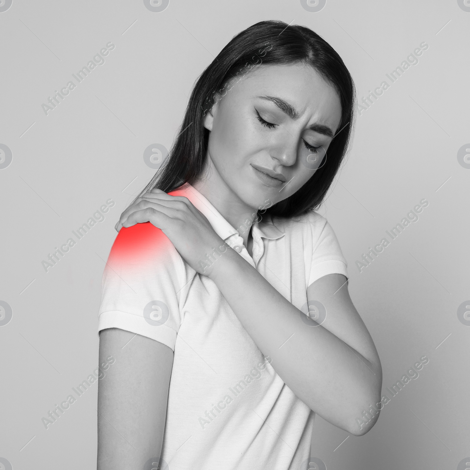 Image of Woman suffering from rheumatism on light background. Black and white effect with red accent in painful area