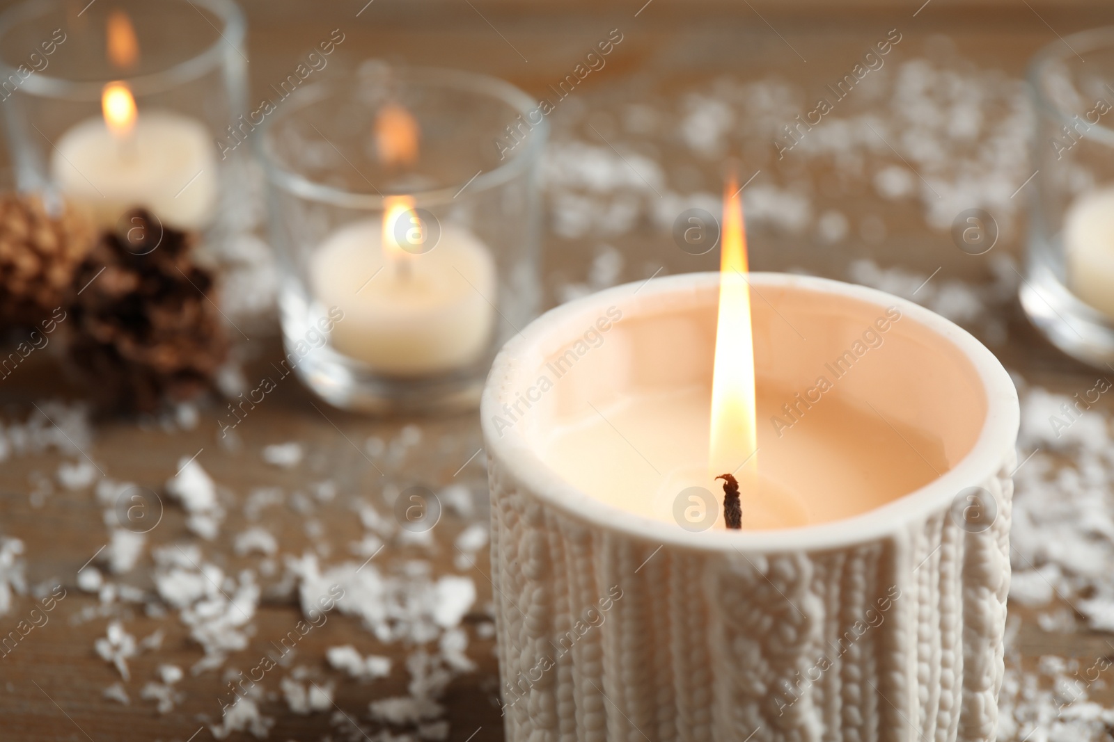 Photo of Candle and Christmas decor on wooden table, space for text