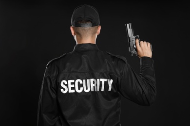 Photo of Male security guard in uniform with gun on dark background