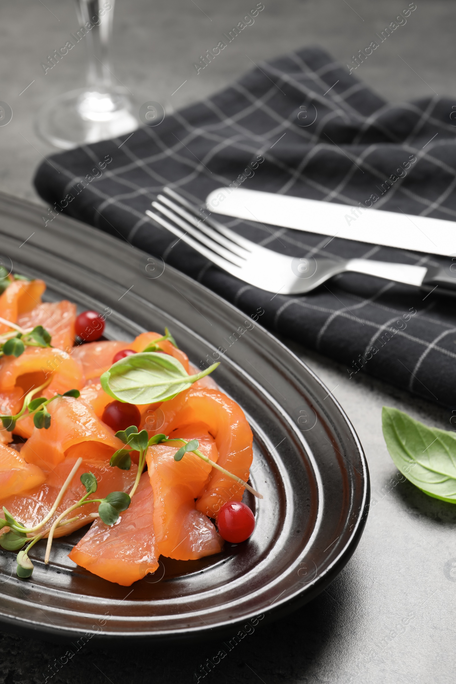 Photo of Delicious salmon carpaccio served on grey table, closeup