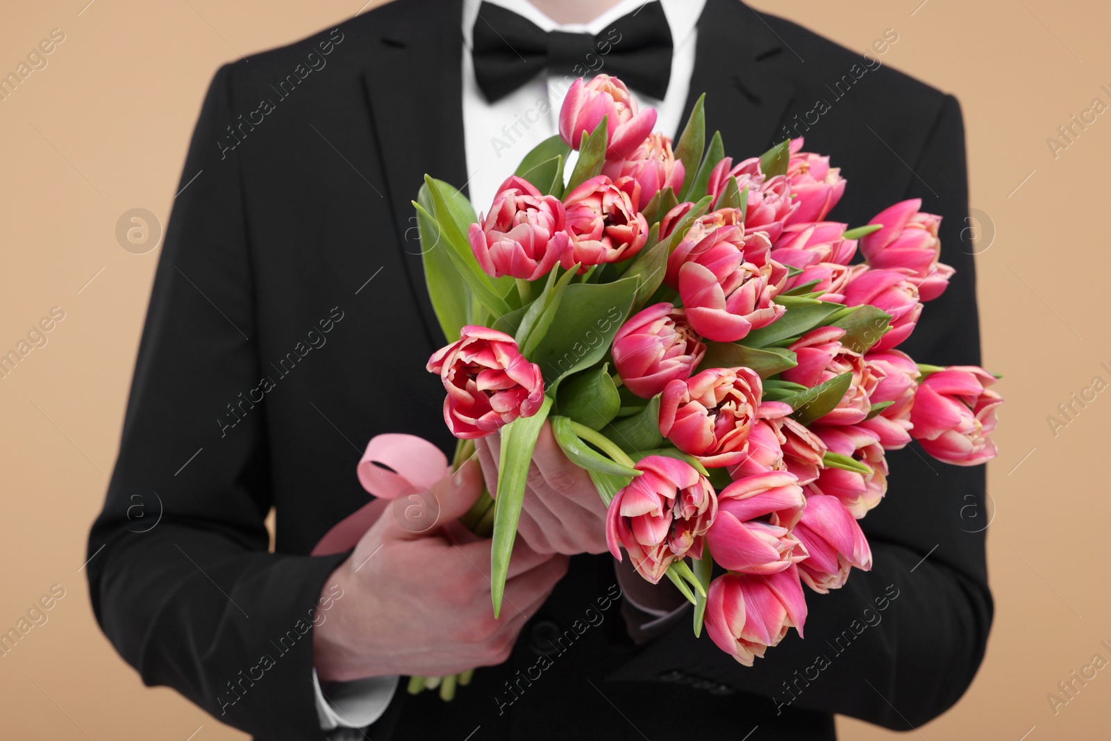 Photo of Man with beautiful bouquet on beige background, closeup