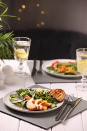 Delicious salad with peach slices served on white wooden table