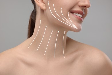 Image of Woman with perfect skin after cosmetic treatment on grey background, closeup. Lifting arrows on her neck and face