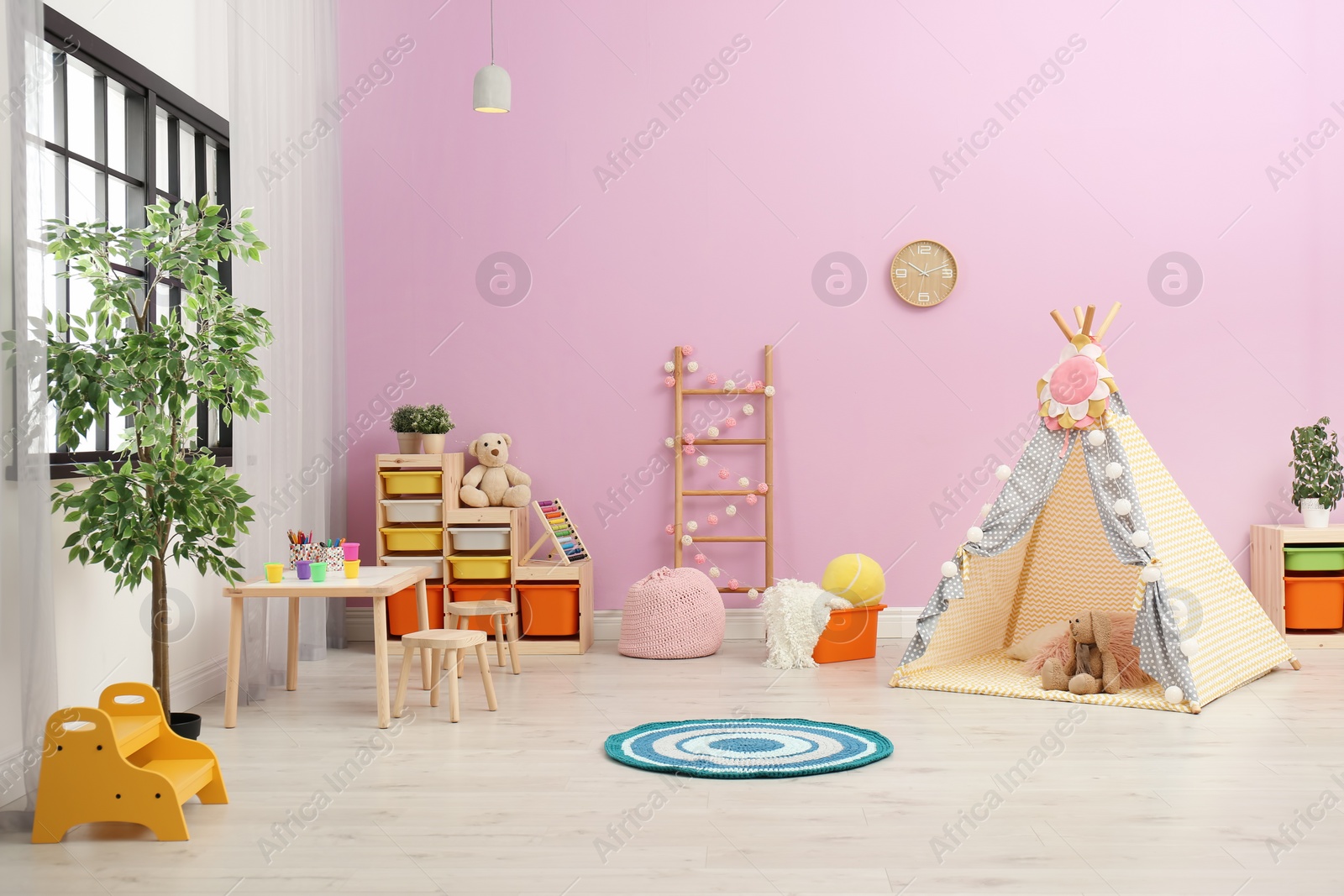 Photo of Modern nursery room interior with play tent for kids