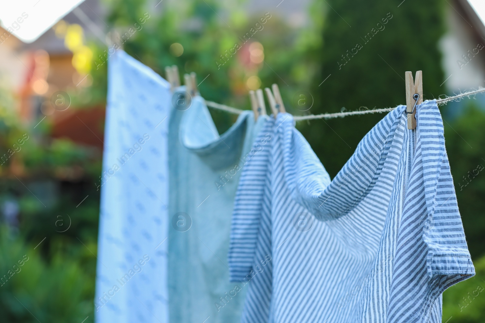 Photo of Washing line with drying shirts against blurred background, closeup