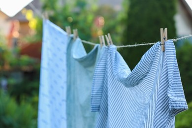 Photo of Washing line with drying shirts against blurred background, closeup