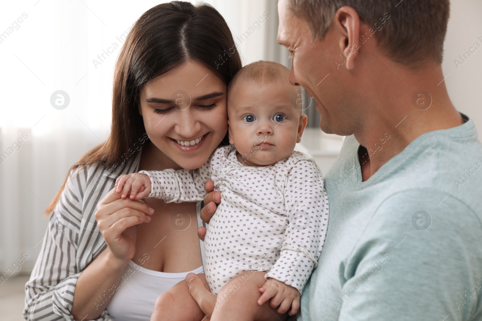 Photo of Happy family with their cute baby at home