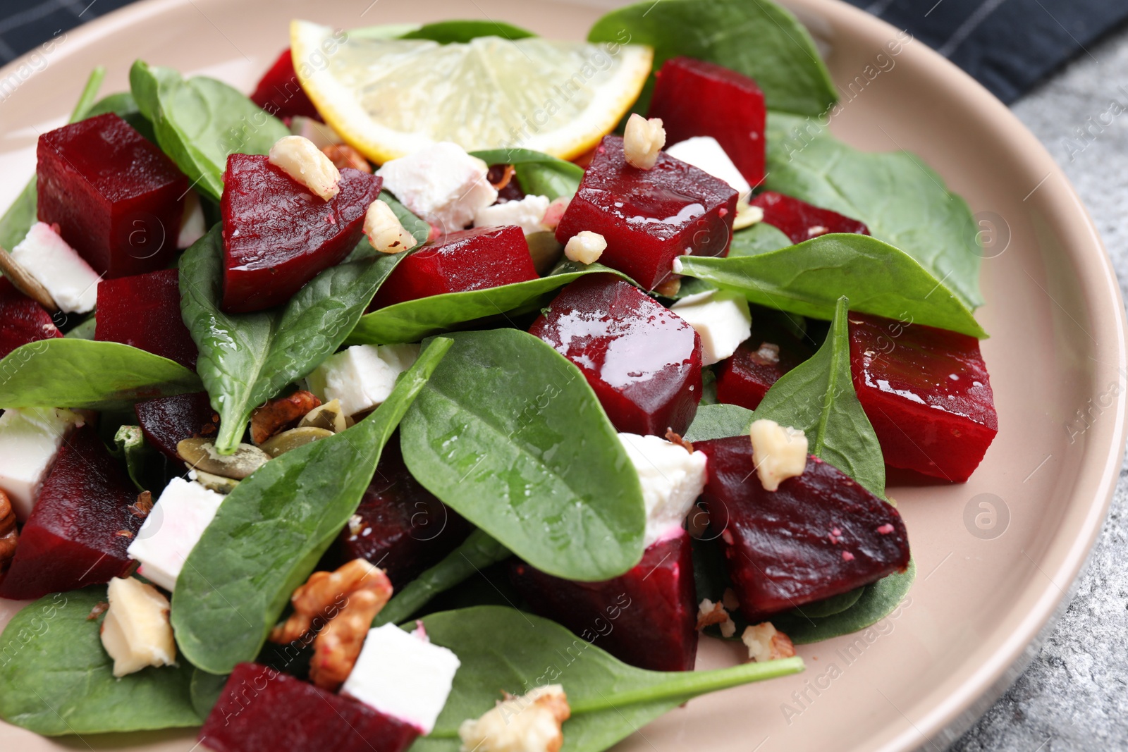 Photo of Delicious beet salad served on grey table, closeup