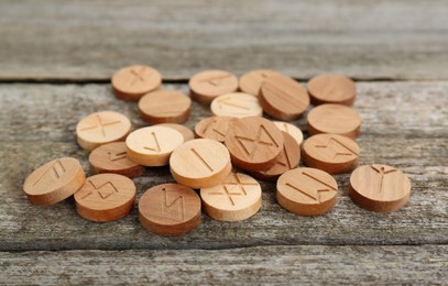 Pile of runes with different symbols on wooden table
