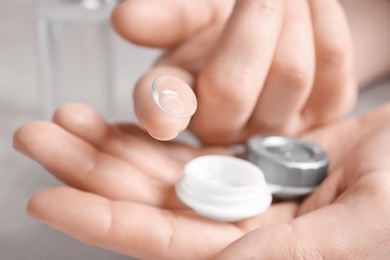 Photo of Woman holding contact lens and case, closeup