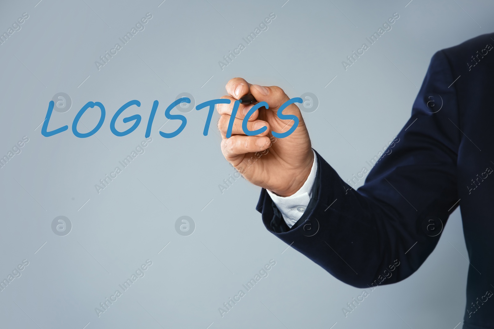 Image of Businessman pointing at word LOGISTICS on virtual screen against light background, closeup 