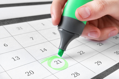 Photo of Woman marking date in calendar with felt pen, closeup