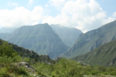 Beautiful mountains and plants under cloudy sky, blurred view