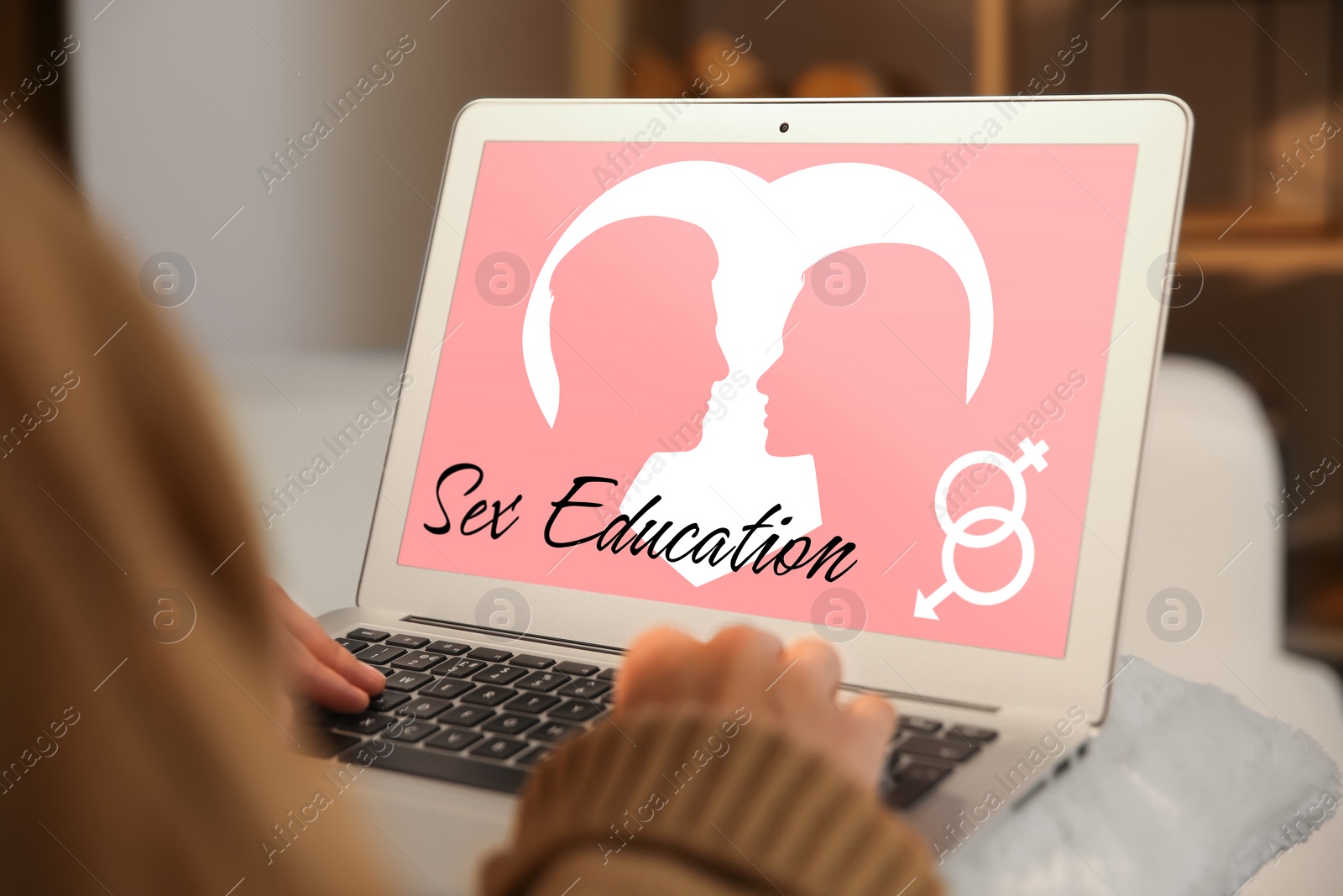 Image of Sex education program. Teenage girl using modern laptop at wooden table, closeup