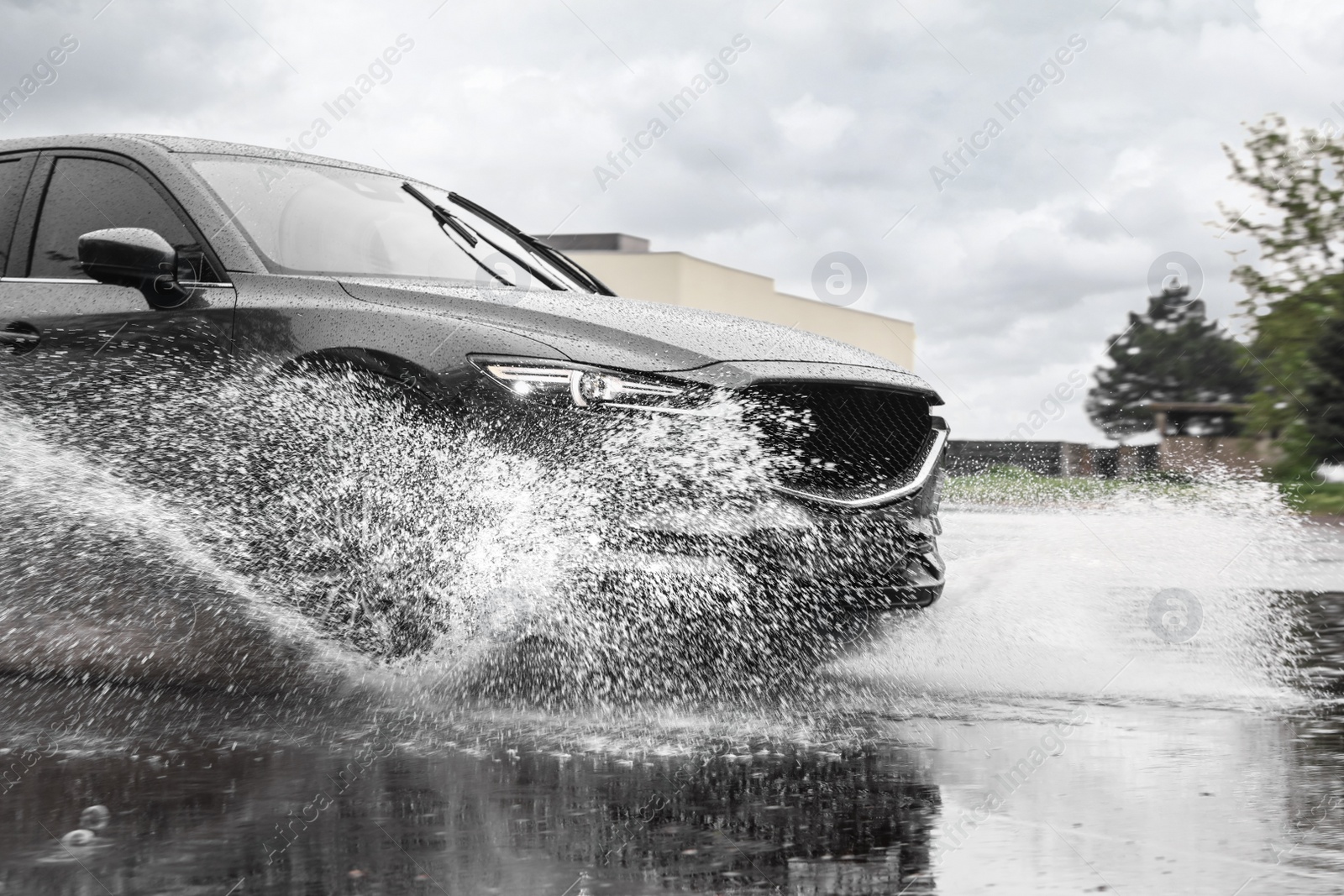 Photo of Modern car driving outdoors on rainy day