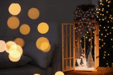 Photo of Vintage wooden lantern with beautiful Christmas composition surrounded by blurred festive lights indoors
