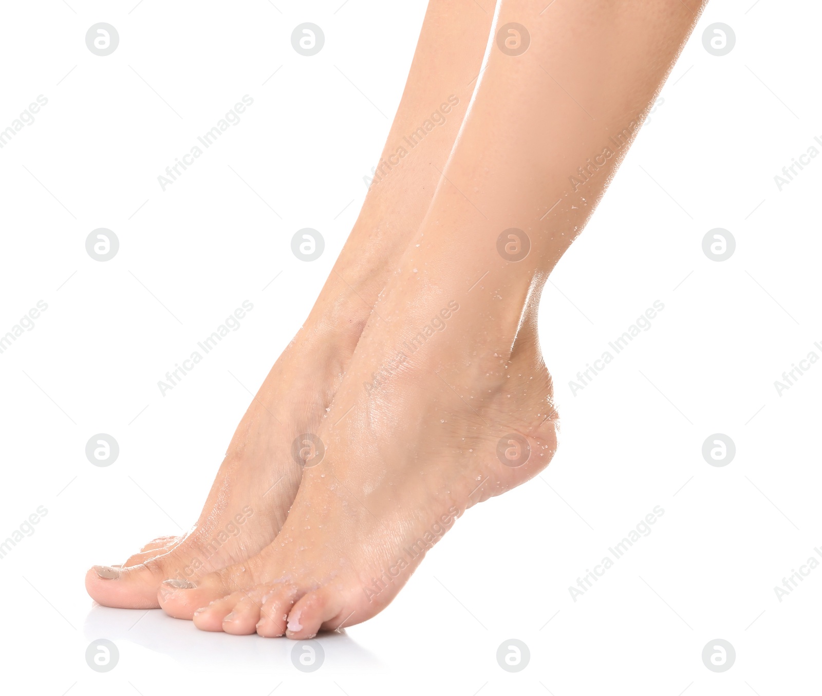 Photo of Female legs with applied natural scrub against white background