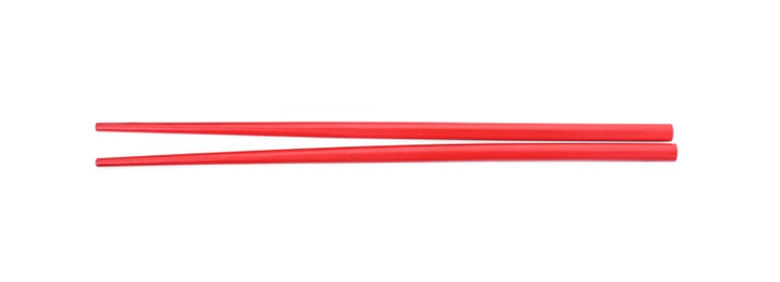 Photo of Pair of red chopsticks isolated on white, top view