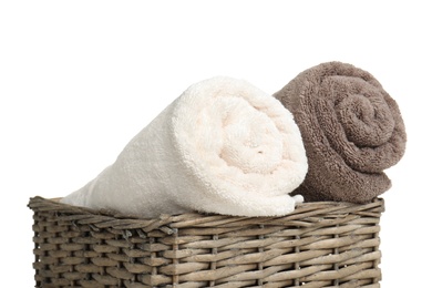 Rolled soft terry towels in wicker basket on white background