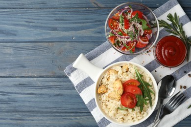 Photo of Delicious chicken risotto served on blue wooden table, flat lay. Space for text