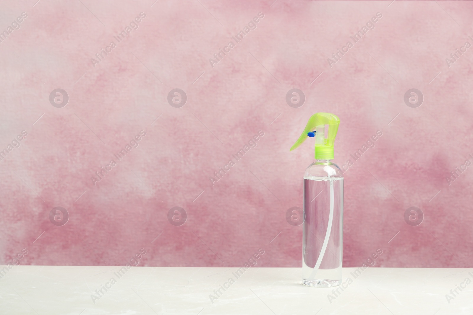 Photo of Spray air freshener on table against color background