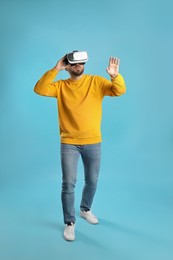 Photo of Man using virtual reality headset on light blue background