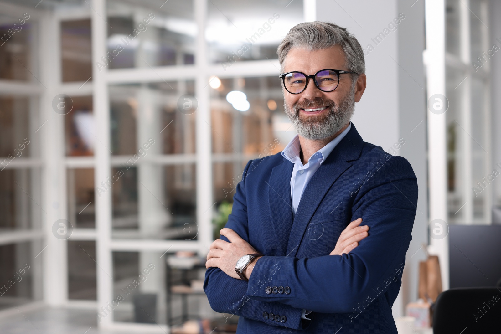 Photo of Portrait of smiling man with crossed arms in office, space for text. Lawyer, businessman, accountant or manager