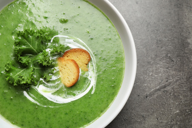 Photo of Tasty kale soup on grey table, top view